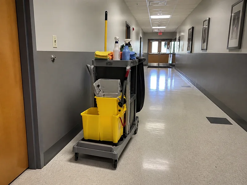Custodial cart with cleaning supplies in a corridor